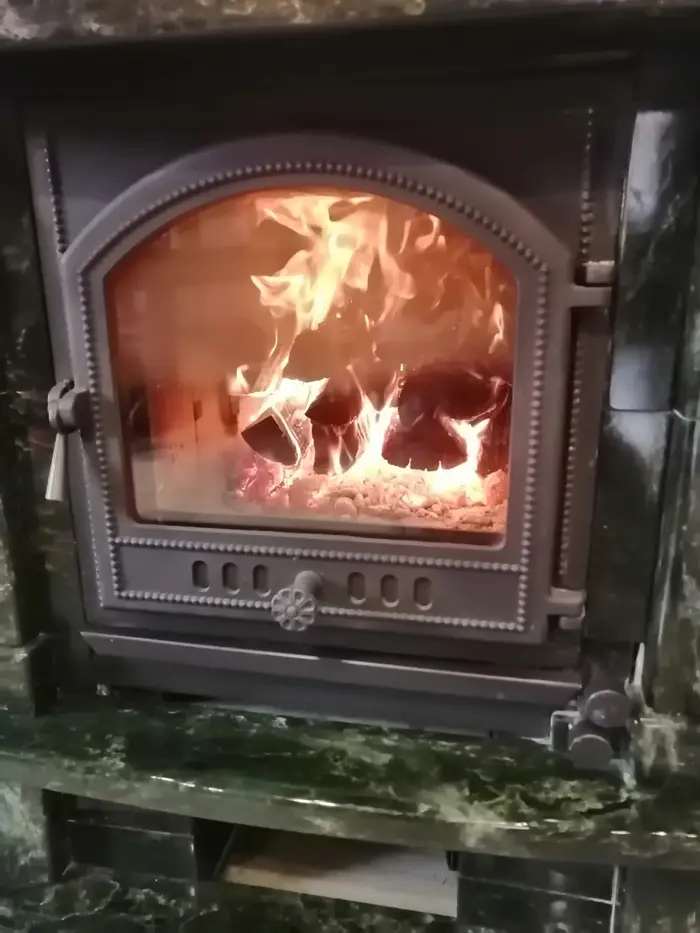 Огонь за топочной дверцей с панорамным стеклом